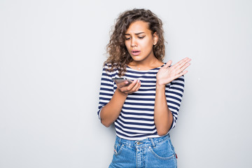 Cheerful curly woman smiling scream and talking on monbile phone isolated on gray background