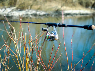 Fishing spinning with reel on a tree