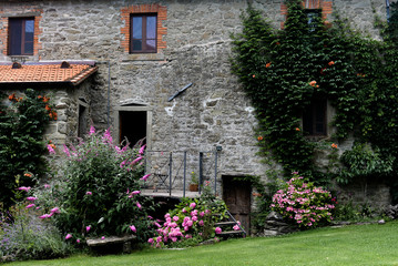 Fototapeta na wymiar Italian stone house with summer flowers and plants