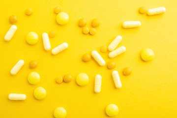 Yellow pills on yellow background