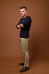 Fototapeta na wymiar Studio shot of young handsome man against brown background