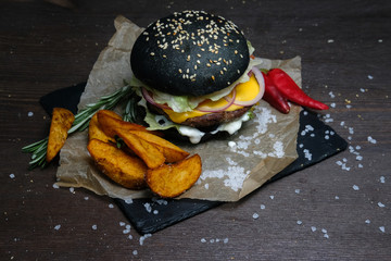black burger on plate on woon table
