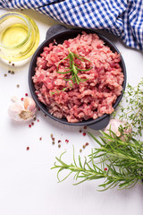 Raw minced meat in bowl  with ingredients for cooking