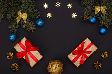 Gift boxes, fir tree branches with cones on black background