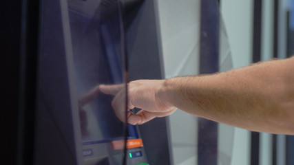 ATM Banking Hand Enter Pin Code In Cash Machine. Male hand typing personal pin code in a ATM cash machine. close up shot