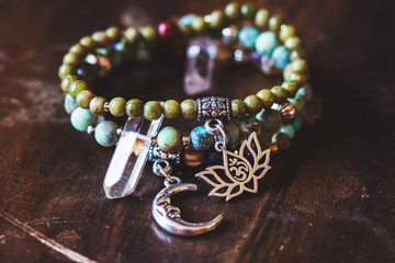 Three mineral stone bracelet with pendants on wooden background