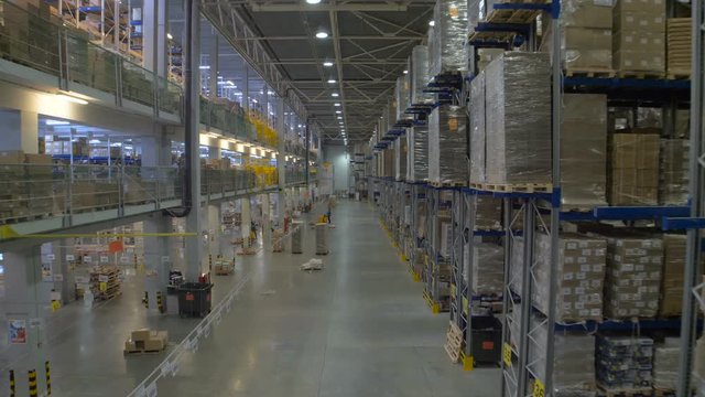 Huge warehouse and forklifts, racks with goods.