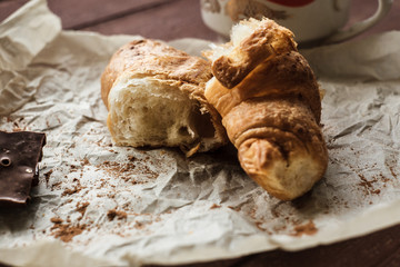 Tasty buttery croissants on old wooden table.