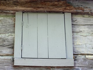 A old wood window frame on the side of the old cabin.