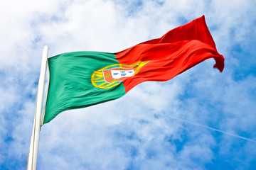 Portugal flag view from below waving against a blue sky