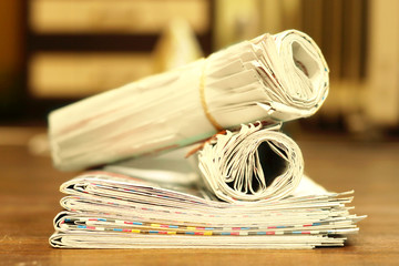 Newspapers folded and rolled, side view   