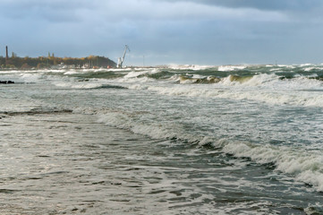 A storm at sea, the waves cover the pier. A severe storm in the Baltic sea.