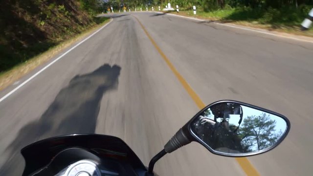 Driving scooter in Thailand over shoulder Mountain Pass