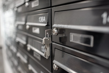 Traditional residential metal postboxes with apartment numbers at the modern multifamily building