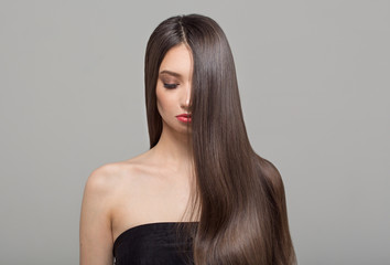 Portrait of a fashion woman and long dark hair. Beautiful make-up. Wavy shiny hair