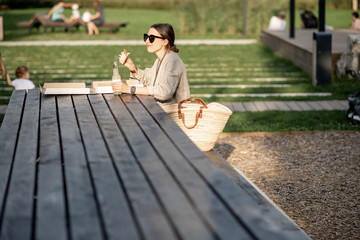 Obraz premium Young woman having a snack with pizza sitting outdoors at the modern public park