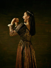 Girl in medieval beautiful dress or costume of the countess at dark studio.