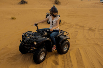 desert Quad Biking. Young girl in helmet driving a Quad bike © Ulia Koltyrina