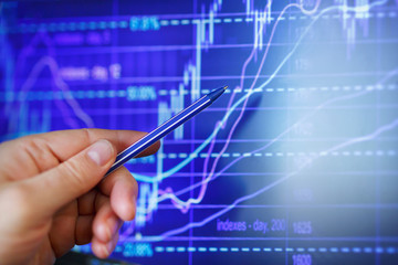 trader's chart of a rise or fall in the exchange rate indicates a hand with a pen. Business presentation.