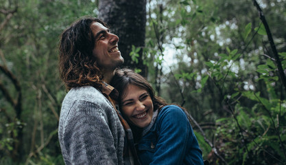 Couple having great time in forest during rain