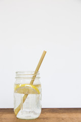 Lemon water and bamboo drinking straw.