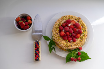 Delicious home made cake with fresh strawberries and rasberries on the white background. Isolated