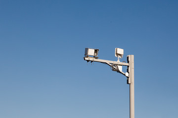 Gray iron pillar with surveillance cameras and speed control on a background of blue sky. Concept of safe driving on the highway