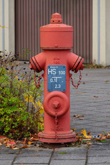 Hydrant mit Hinweisschild vor Garage