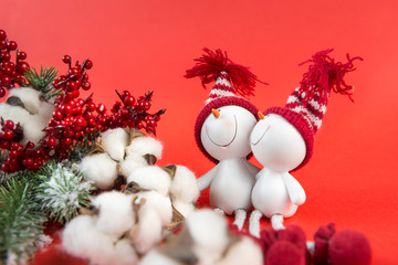 1 spruce branch, red berries, cotton branch, 2 toy snowmen, red background, close up, Christmas decor