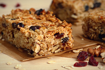 Homemade granola bars with nuts and cranberries over wooden background