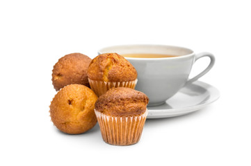 Cup of tea with small cupcakes on white.