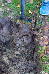 Man digging a ditch with a shovel in autumn