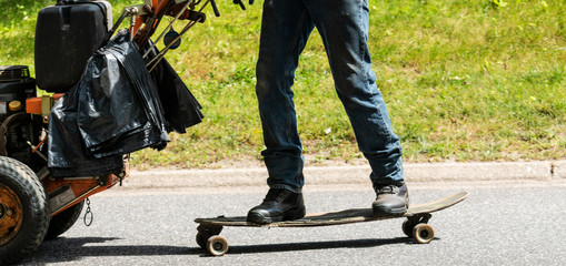 Landscaper on skateboard with lawnmower