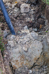 Man digging a ditch with a shovel in autumn