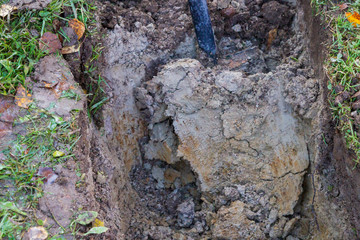 Man digging a ditch with a shovel in autumn
