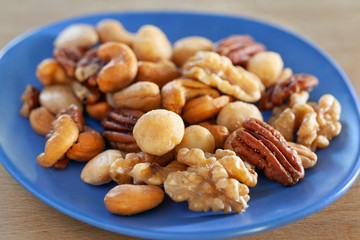 Salted nuts mix on a blue dish
