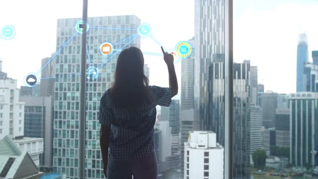 Work of an IT specialist woman before which a hologram of the problem is being developed, against the backdrop of modern office buildings. 3840x2160 - Powered by Adobe