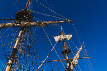 Sailors work with sails at a height on a traditional sailboat