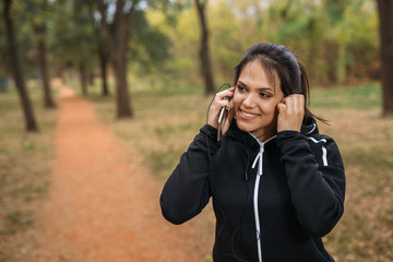 Woman listening to music while out running in park