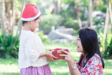 Happy family with mother and daughter holding christmas gift,X-mas concept