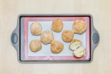 freshly baked buns on a silicone baking mat, on an iron tray