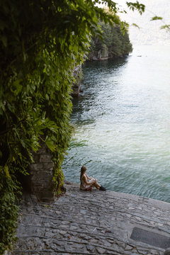 woman sitting by lake como