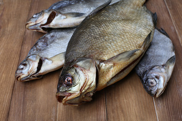 Smoked and dried fishes on wooden background