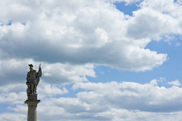 An ancient monument on a column on the background of bright sunny sky