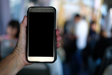hand holding smartphone while riding on commuter bus. people traveling by public transport with mobile phone