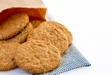 Homemade shortbread cookies made of oatmeal  stacked on cloth and paper bag on white background. Concept food healthy snack for enjoy in holiday. With copy space for text.