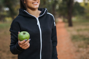 Woman jogger holding apple