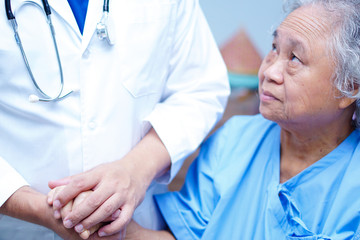 Doctor holding touching hands Asian senior or elderly old lady woman patient with love, care, helping, encourage and empathy at nursing hospital ward : healthy strong medical concept 