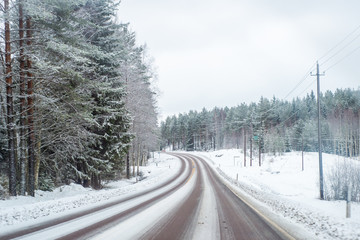 Car with lights on a snow covered road.
