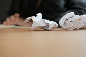 crumpled paper with tired overworked businessman sleeping at workplace